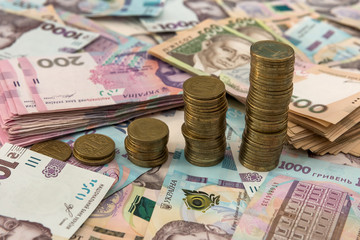 500 and 1000 bill ukraine money as background. gold coin lying on pile of grivna