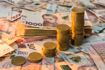 Close up coin stacked growing as financial  chart lying on ukraine money as background. For business growth