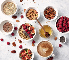 Ingredients for a healthy breakfast, oatmeal with raspberries, figs, pecans, almonds, flax seeds, chia seeds with honey and coffee. Good morning, health concept. Top view