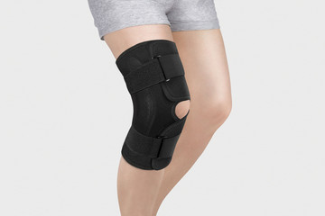 Knee Support Brace on leg isolated on white background. Orthopedic Anatomic Orthosis. Braces for...