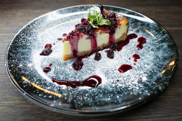 delicious creamy dessert, cheesecake with cherry jam, a leaf of mint and whipped cream