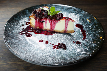 delicious creamy dessert, cheesecake with cherry jam, a leaf of mint and whipped cream