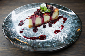 delicious creamy dessert, cheesecake with cherry jam, a leaf of mint and whipped cream