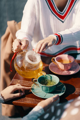 Two attractive girls enjoy a tea party