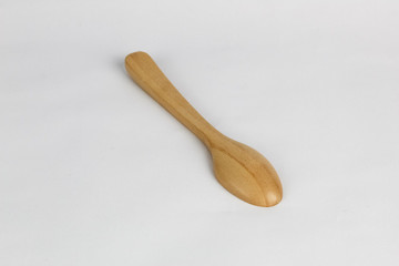 Brown wood spoon at the white background with the lighting