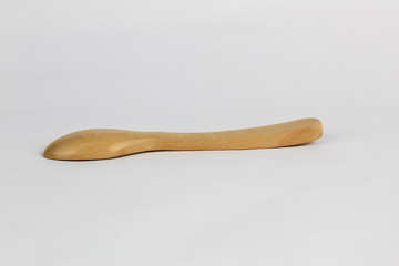 Brown wood spoon at the white background with the lighting