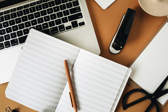 Home office desk workspace with laptop on ginger background. Flat lay, top view girl boss work business concept.
