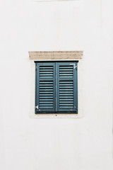 Minimal travel concept. Lonely blue wood shutters on white building. Front view. Europe.