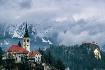 Lake Bled Island during winter with Karavanke Alps covered in clouds