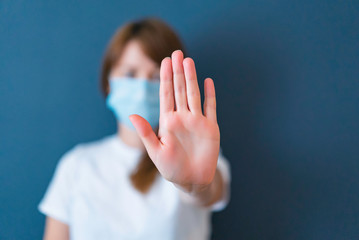 Coronavirus concept. Girl wearing mask for protection from disease and show stop hands gesture for...