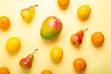 Fresh fruits scattered on a yellow background, top view
