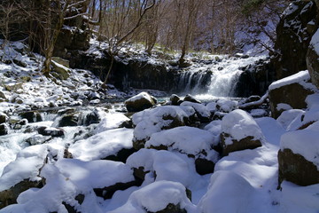 早春の雪が残る渓流