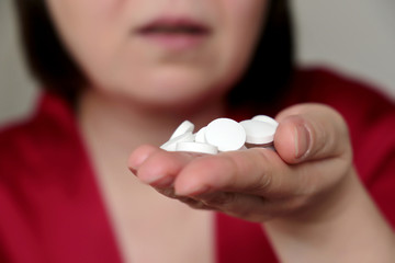 Woman taking pills, girl with open mouth holding white tablets in palm of hand. Treatment of coronavirus, medication, calcium drug 