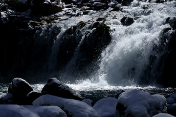 早春の雪が残る渓流
