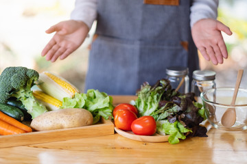 Closeup image of a female chef showing and preparing fresh mixed vegetables to cook in kitchen