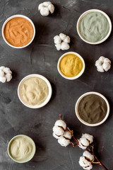 Blue, yellow, white. red, black cosmetic clay background on black table top-down pattern