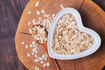 Oatmeal in heart shaped plate on wooden surface