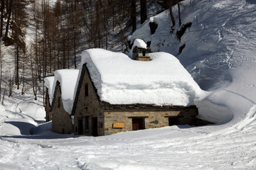 Naklejka premium Devero Park ( Verbano-Cusio-Ossola ), Italy - January 15, 2017: Typical houses in Alpe Devero Park, Ossola Valley, VCO, Piedmont, Italy