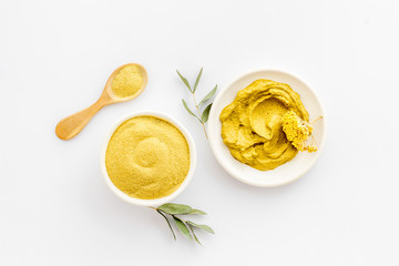 Yellow cosmetic clay - skin cleansing concept - on white background top-down