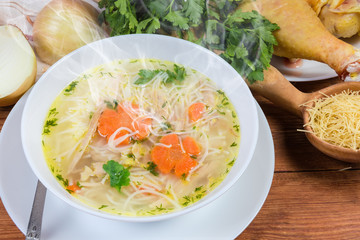 Hot chicken vermicelli soup in bowl against the raw ingredients