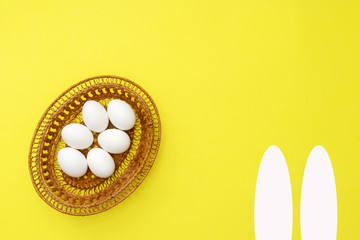 White eggs in pottle on yellow