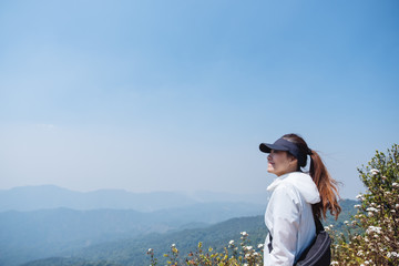 A woman hiking and standing on the top of mountains looking at a beautiful view