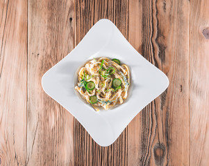 Pasta dish with a sour cream and herbs on wooden boards