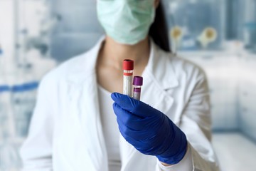 female scientist in laboratory. doctor holding blood test tube