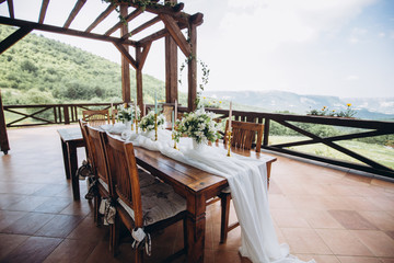 The wedding table decorated with fresh flowers is newlywed with a view of the mountains. 