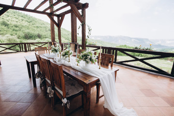 The wedding table decorated with fresh flowers is newlywed with a view of the mountains. 