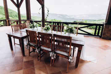 The wedding table decorated with fresh flowers is newlywed with a view of the mountains. 