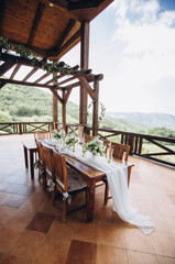 The wedding table decorated with fresh flowers is newlywed with a view of the mountains. 