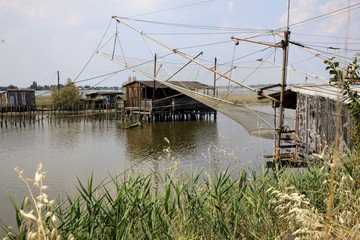 Po river (FE),  Italy - April 30, 2017: An old Fisherman's house with a net on Po river, Delta Regional Park, Emilia Romagna, Italy