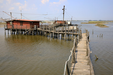 Fototapeta premium Po river (FE), Italy - April 30, 2017: The pier with an old Fisherman's house on Po river, Delta Regional Park, Emilia Romagna, Italy