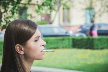 Young girl smoke cigarette at park