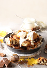 The concept of American cuisine. Pastries and desserts. Cinnabon with cinnamon and white glaze. Buns with cinnamon and cream cheese on a light background. Background image, copy space