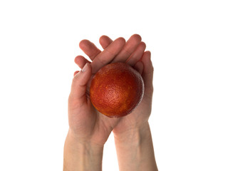 White woman holds a bloody orange in her hand