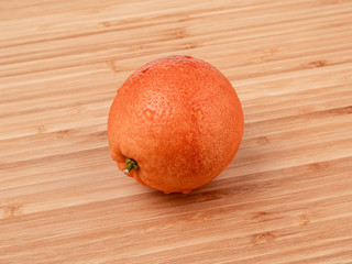Bloody orange on a wooden surface side view close-up