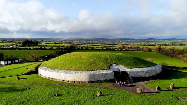 Newgrange round building in green field in ireland