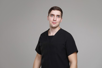 Surprised young white man in casual work black clothes isolated on gray background.