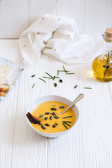 Pumpkin cream soup with cheese and onions on a white board. Still life flat lay