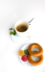 Coffee, plate, bagels, marmalade, sprig with green leaves, on a white background