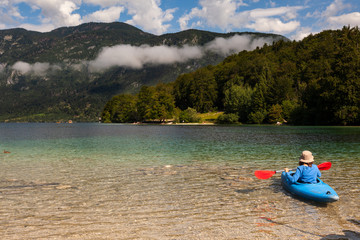 Fototapeta na wymiar Girl kayaking in the Bohinj lake