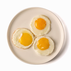tree fried eggs on white plate isolated on white background