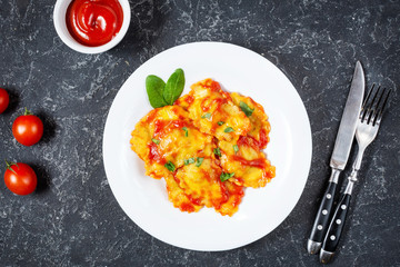 Ravioli with tomato sauce and basil on dark stone background. Delicious pasta