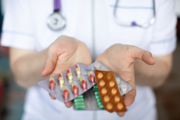 Female doctor holding pills close-up.