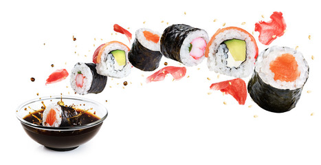 Concept of flying sushi with ingredients isolated on white background. Piece of sushi drops in a bowl with soy sauce.