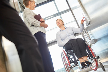 Woman in a wheelchair presses a button in the elevator