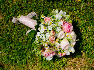Beautiful bouquet of the bride on a green lawn.