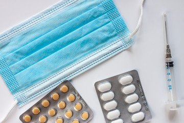 thermometer syringe blue mask and pills blisters